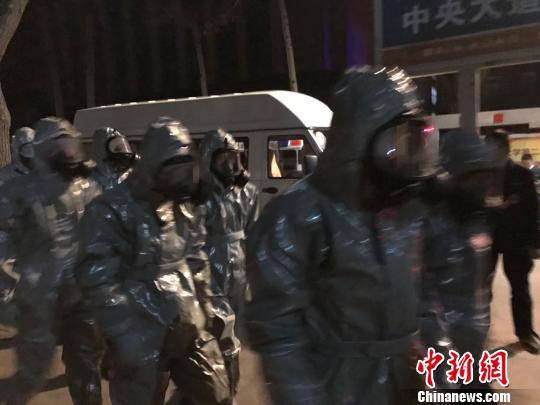 十几名身着防护服的人员头戴面具进入事发地。　胡健 摄